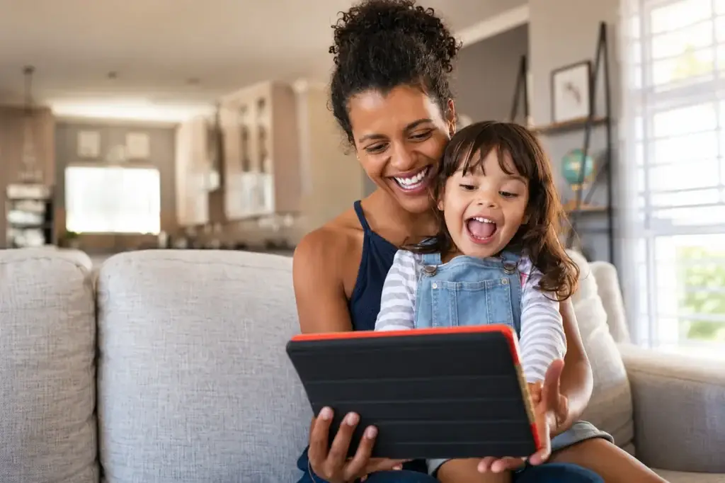 Parent and child using a kids' educational app on a tablet at home